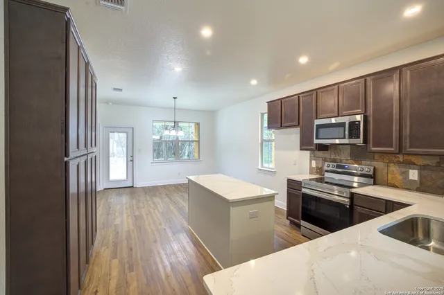 a kitchen with granite countertop a refrigerator and a sink