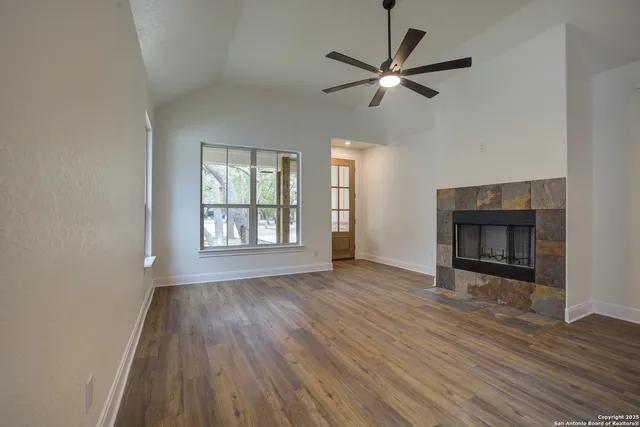 wooden floor fireplace and windows in an empty room