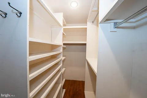 a view of an empty room with wooden floor and window