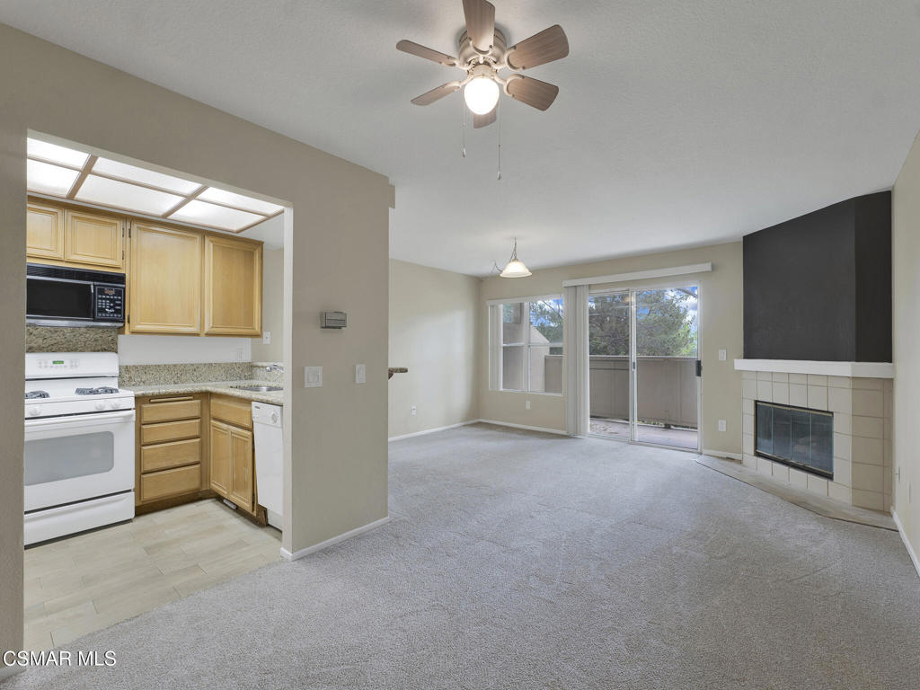 2731 Erringer Road, Unit 28 Simi Valley, CA 93065 - Photo 13 of 30 a view of a kitchen with a stove cabinets a ceiling fan and a fireplace