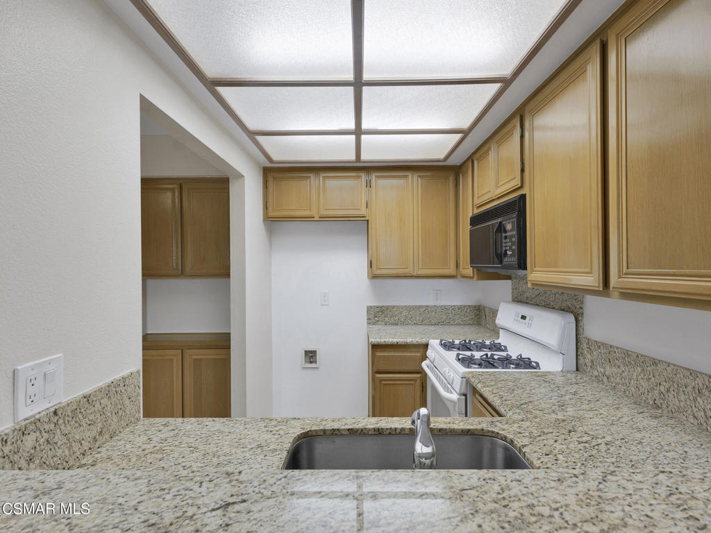 2731 Erringer Road, Unit 28 Simi Valley, CA 93065 - Photo 16 of 30 a kitchen with stainless steel appliances granite countertop a stove a sink and a microwave