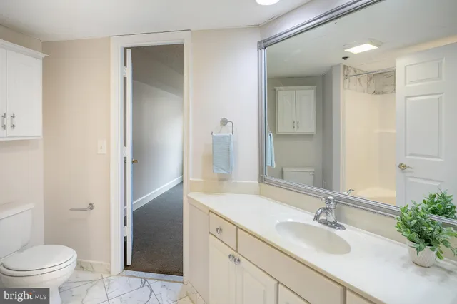 a bathroom with a granite countertop sink a mirror a bathtub and shower