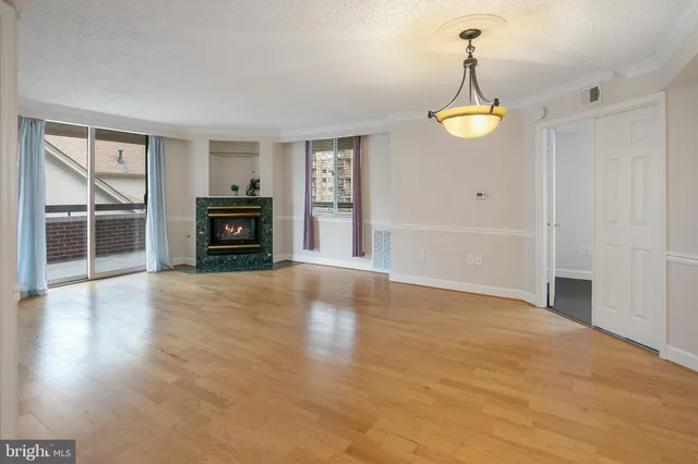 a view of a livingroom with a fireplace wooden floor and window