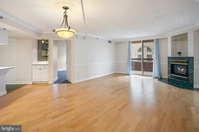 a view of an empty room with a fireplace and a window