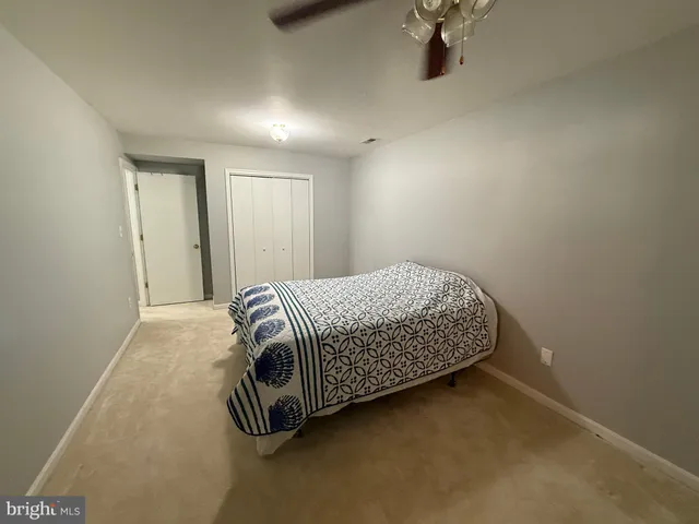 an empty room with mirror and bathroom view
