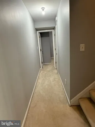 an empty room with wooden floor chandelier fan and windows