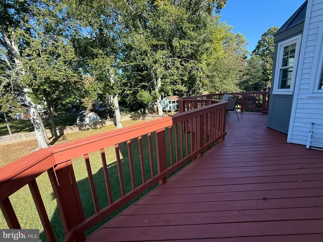 a balcony with wooden floor and trees in the back