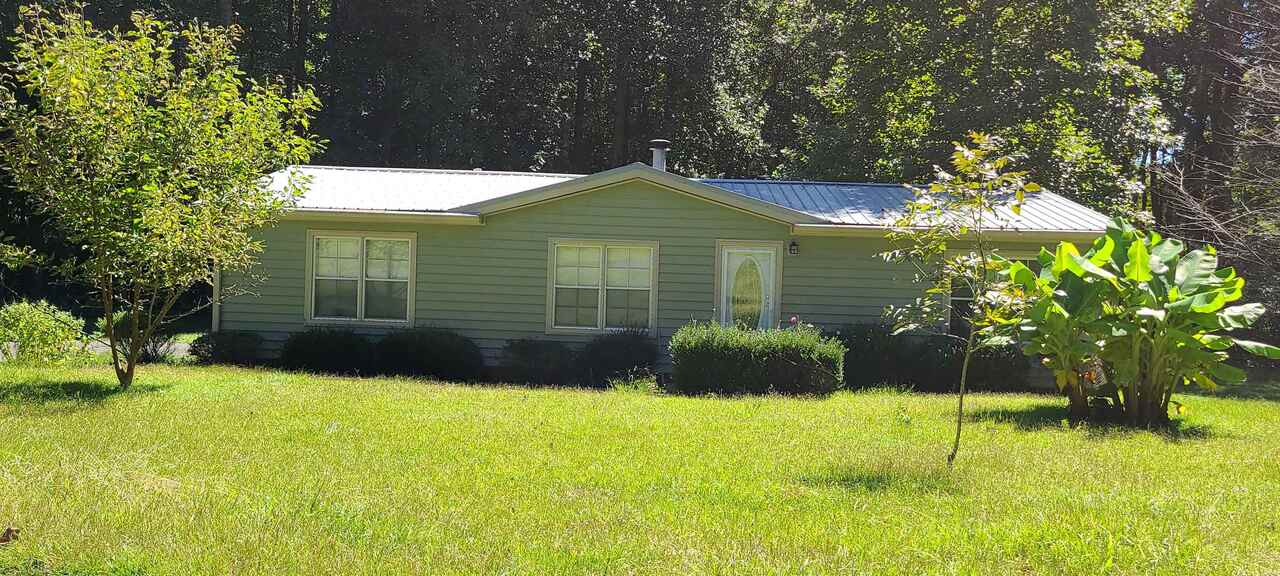 521 Old Harden Orchard Road Commerce, GA 30529 - Photo 1 of 1 a backyard of a house with plants and large trees