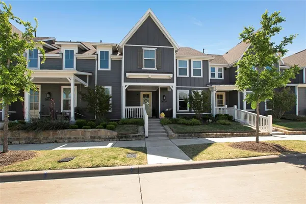 a view of a house with small yard plants and palm tree