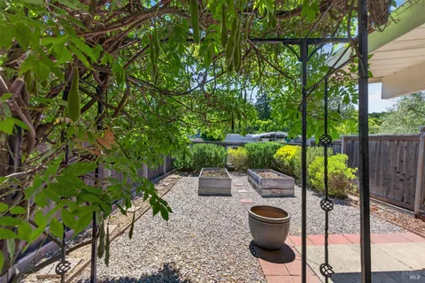 a view of a patio with table and chairs potted plants with wooden floor and fence