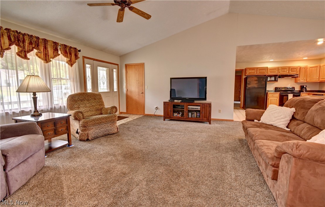 3318 Simpson Road Southeast Dennison, OH 44621 - Photo 9 of 31 Living room featuring high vaulted ceiling, light carpet, and ceiling fan