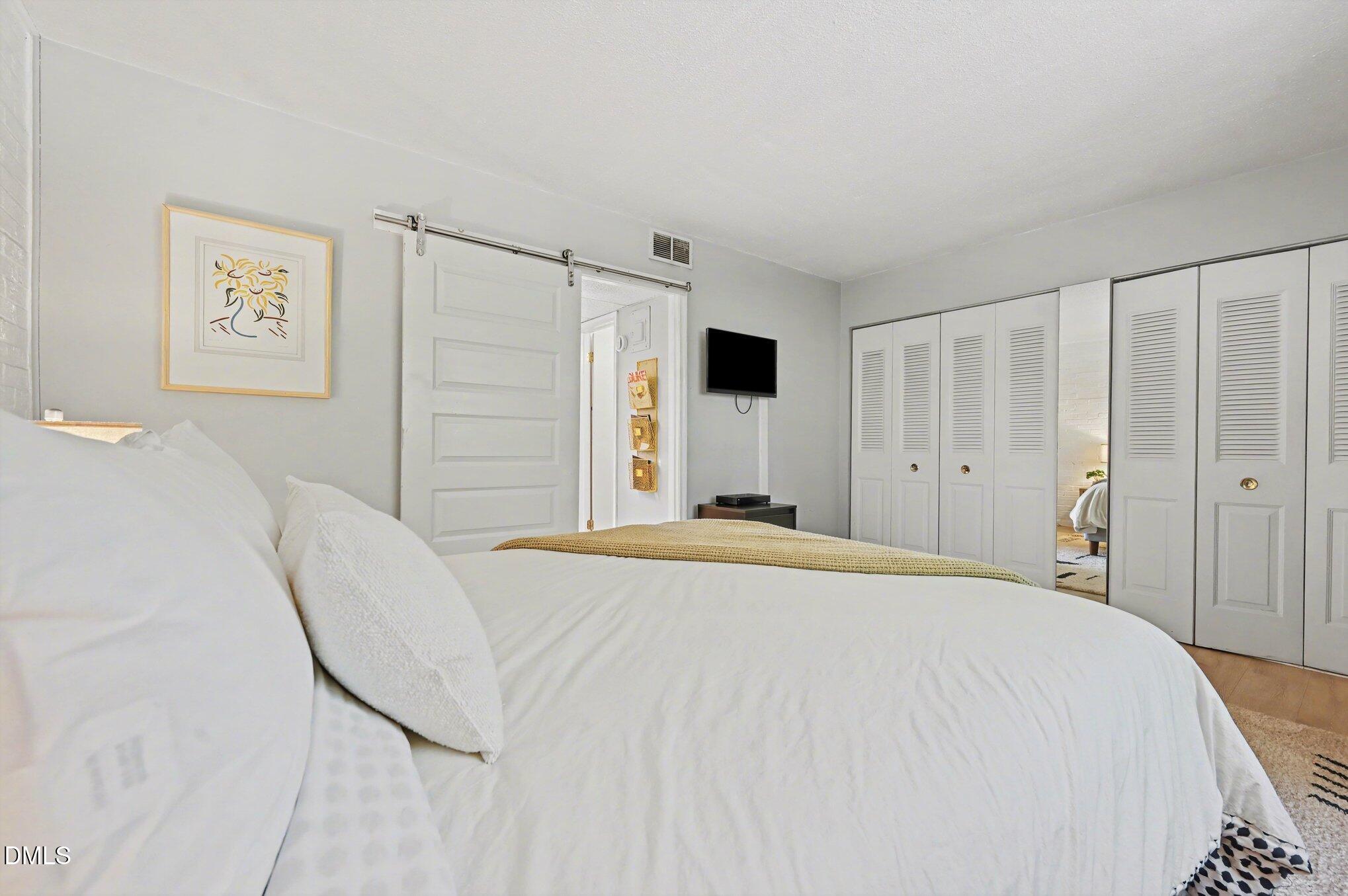 807 West Trinity Avenue, Unit 252 Durham, NC 27701 - Photo 12 of 23 a bedroom with a bed and a cabinets
