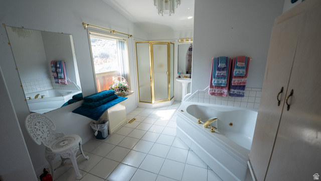 7500 Spring Canyon Road Helper, UT 84526 - Photo 16 of 64 Spacious bathroom featuring a corner jetted tub, a separate corner shower with gold-toned framing, a pedestal sink, and white square floor tiling