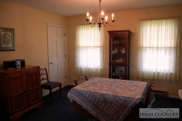 393 Harrison Road Boone, NC 28607 - Photo 23 of 28 a spacious bedroom with a bed window and chandelier