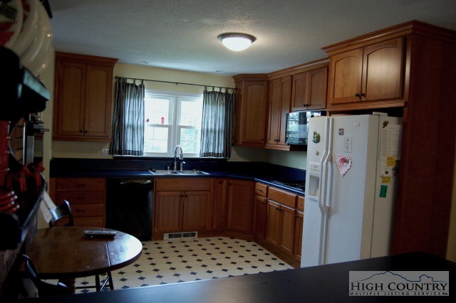 393 Harrison Road Boone, NC 28607 - Photo 27 of 28 a kitchen with stainless steel appliances granite countertop a sink a stove and a refrigerator