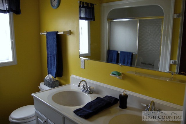393 Harrison Road Boone, NC 28607 - Photo 8 of 28 a bathroom with a granite countertop sink and a mirror