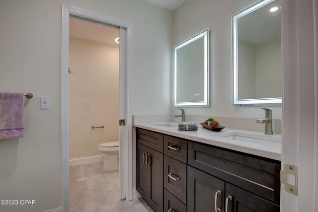 a bathroom with a granite countertop sink a toilet and a mirror
