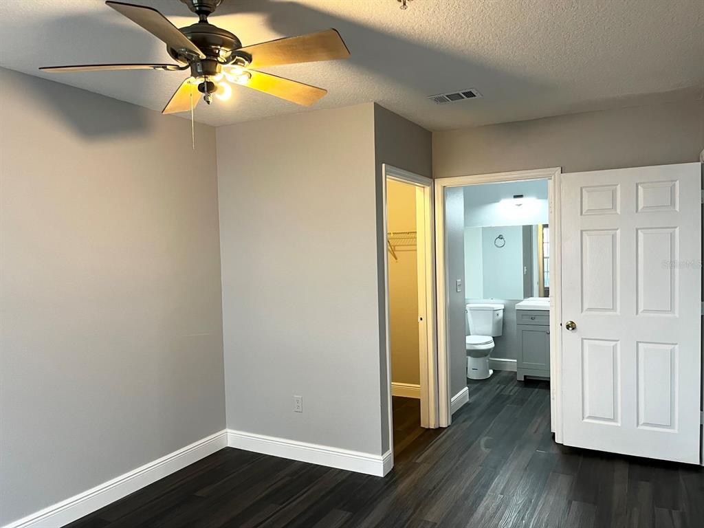 4352 South Kirkman Road, Unit 1203 Orlando, FL 32811 - Photo 11 of 27 Master bedroom with ensuite, walk-in closet and new vinyl flooring