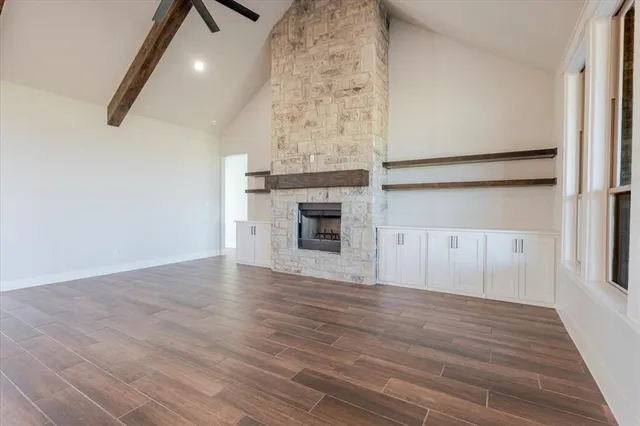 wooden floor fireplace and windows in an empty room