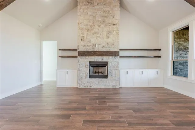 a view of empty room with wooden floor and fireplace
