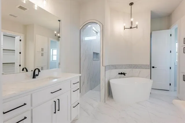 a bathroom with a tub sink double vanity and tub