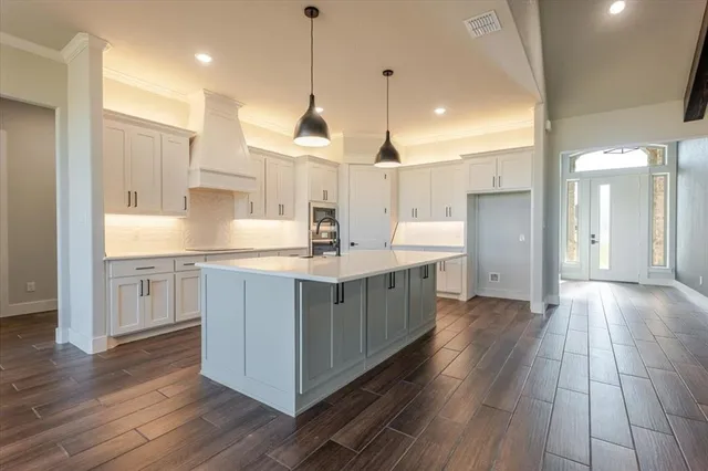 a kitchen with kitchen island a sink and a stove top oven