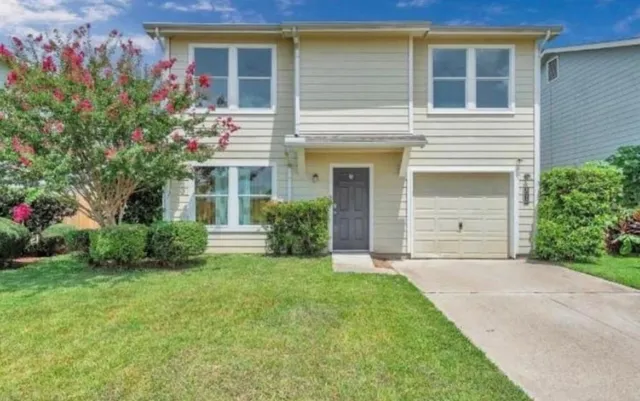 a front view of a house with a garden and yard