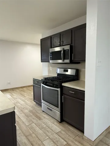 a kitchen with granite countertop a stove and a microwave
