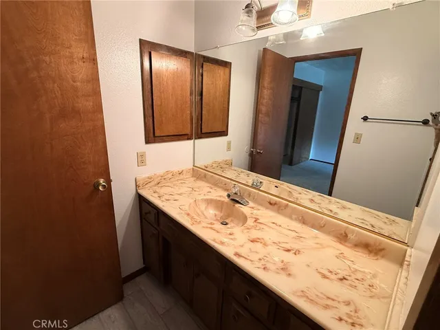 a bathroom with a granite countertop sink and a mirror