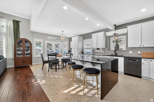 14738 Tangle Hill Road Herriman, UT 84096 - Photo 16 of 66 Bright kitchen and dining area featuring a large center island with seating, white shaker cabinetry, stainless steel appliances, and a mosaic tile backsplash