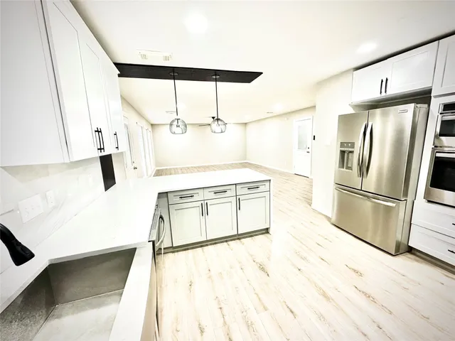 a kitchen with stainless steel appliances a refrigerator and a stove top oven