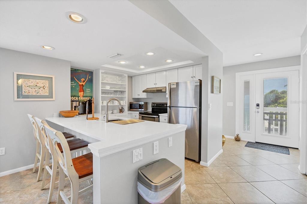 420 Gulf Boulevard, Unit 13 Boca Grande, FL 33921 - Photo 13 of 36 a kitchen with stainless steel appliances a refrigerator and a stove top oven