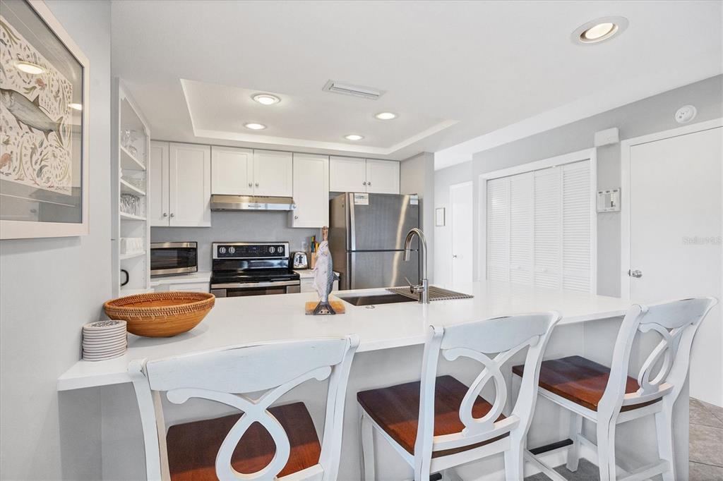 420 Gulf Boulevard, Unit 13 Boca Grande, FL 33921 - Photo 14 of 36 a kitchen with stainless steel appliances a stove a sink and a microwave