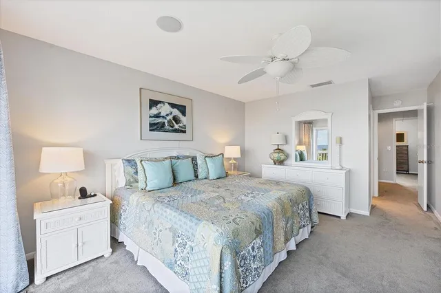 a spacious bedroom with a large bed and a chandelier