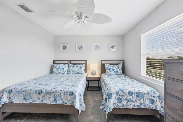 a bedroom with two beds and a chandelier