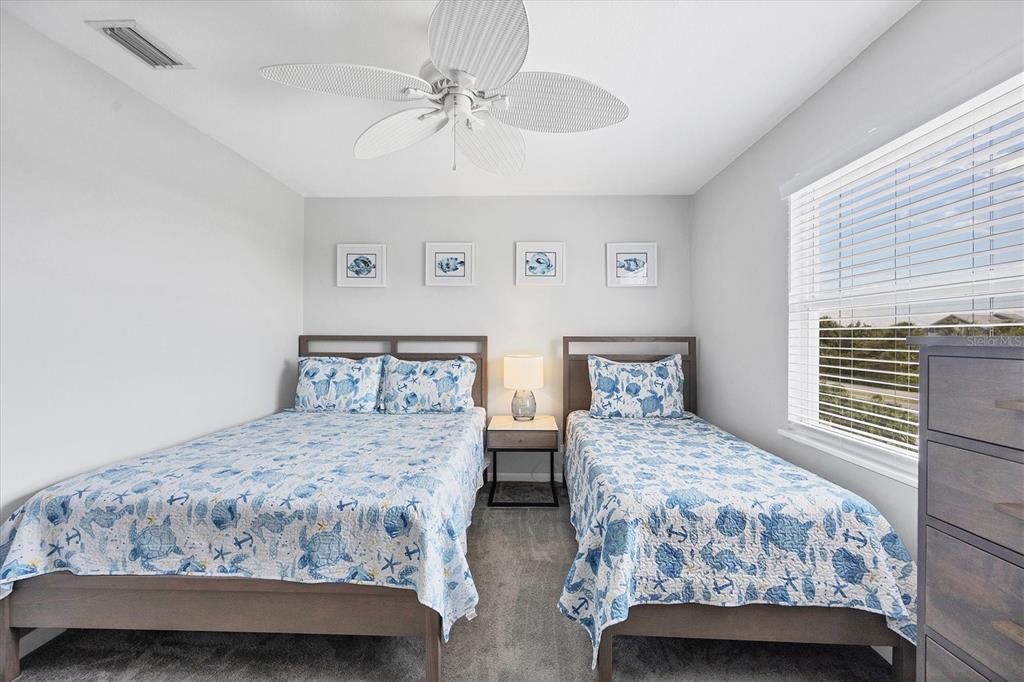 420 Gulf Boulevard, Unit 13 Boca Grande, FL 33921 - Photo 28 of 36 a bedroom with two beds and a chandelier