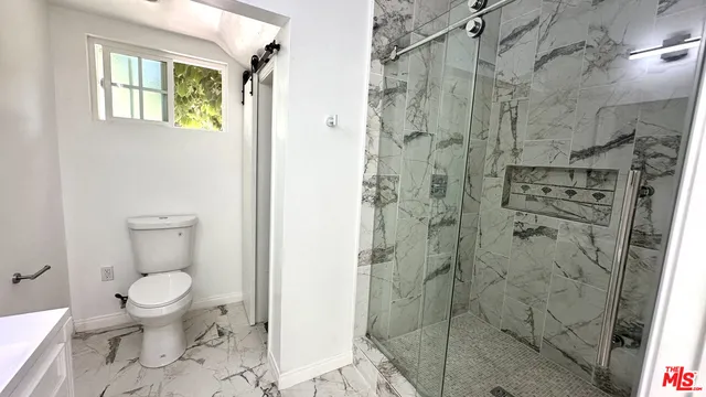a bathroom with a toilet and a shower