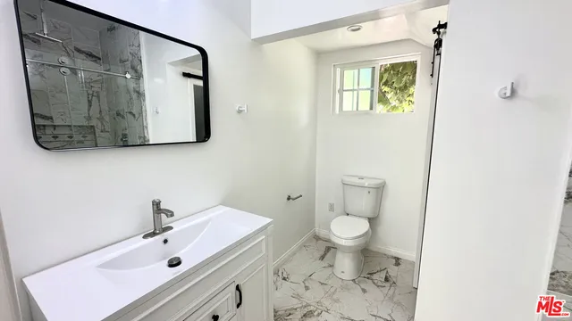 a bathroom with a sink toilet and a mirror