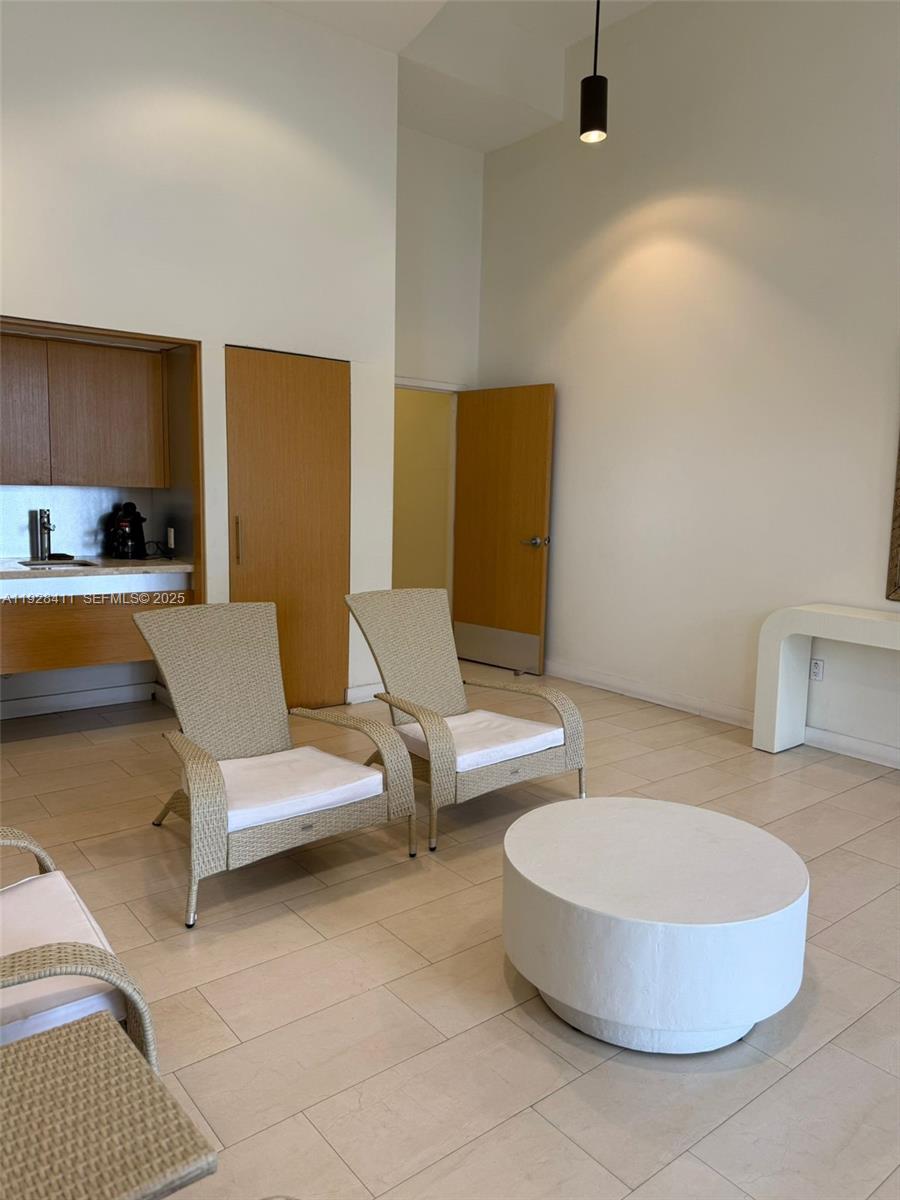 8911 Collins Avenue, Unit 1103 Surfside, FL 33154 - Photo 18 of 19 a living room with furniture and a lamp