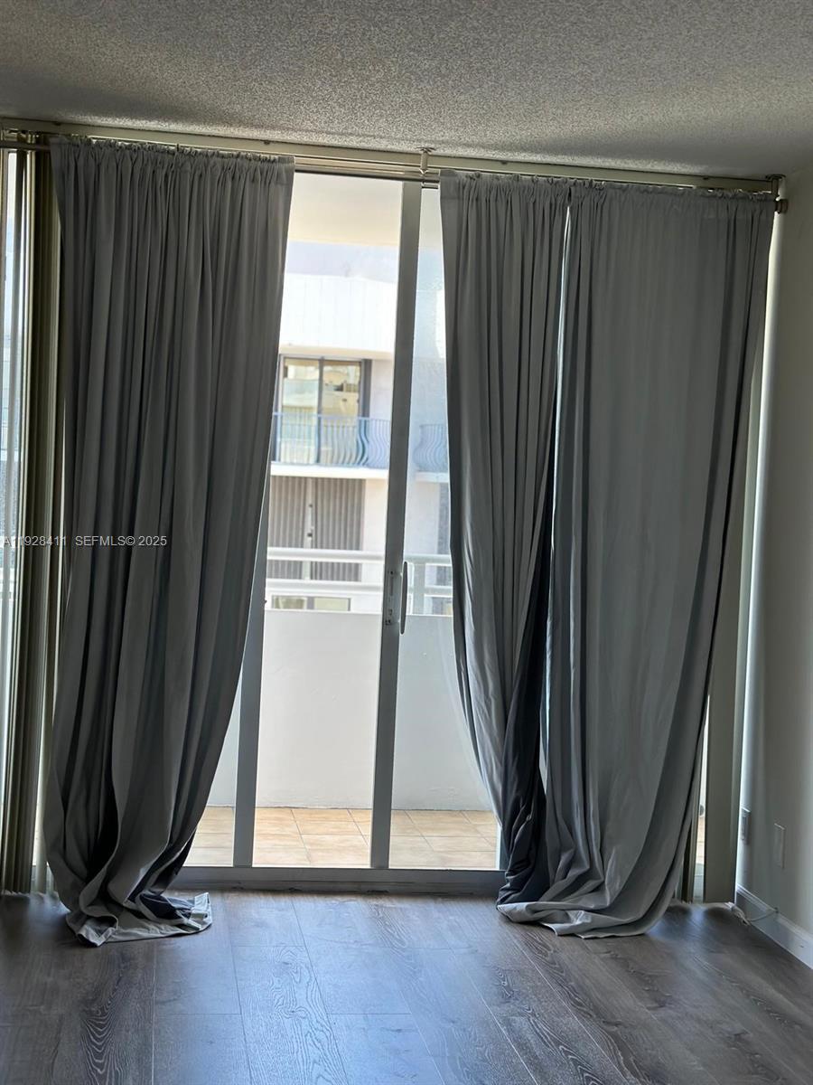 8911 Collins Avenue, Unit 1103 Surfside, FL 33154 - Photo 7 of 19 a view of a room with wooden floor and a window