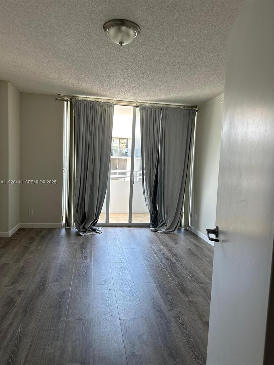 8911 Collins Avenue, Unit 1103 Surfside, FL 33154 - Photo 8 of 19 an empty room with wooden floor and closet