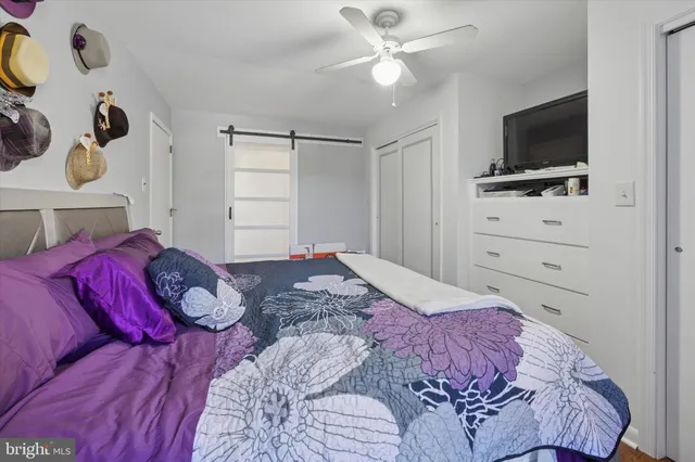 a bedroom with a bed and a flat tv screen on dresser