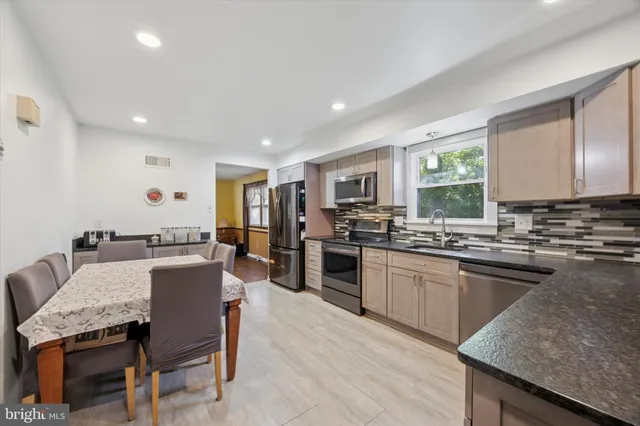 a large kitchen with a table and chairs