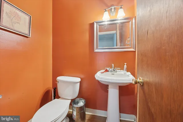 a bathroom with a toilet a sink and mirror
