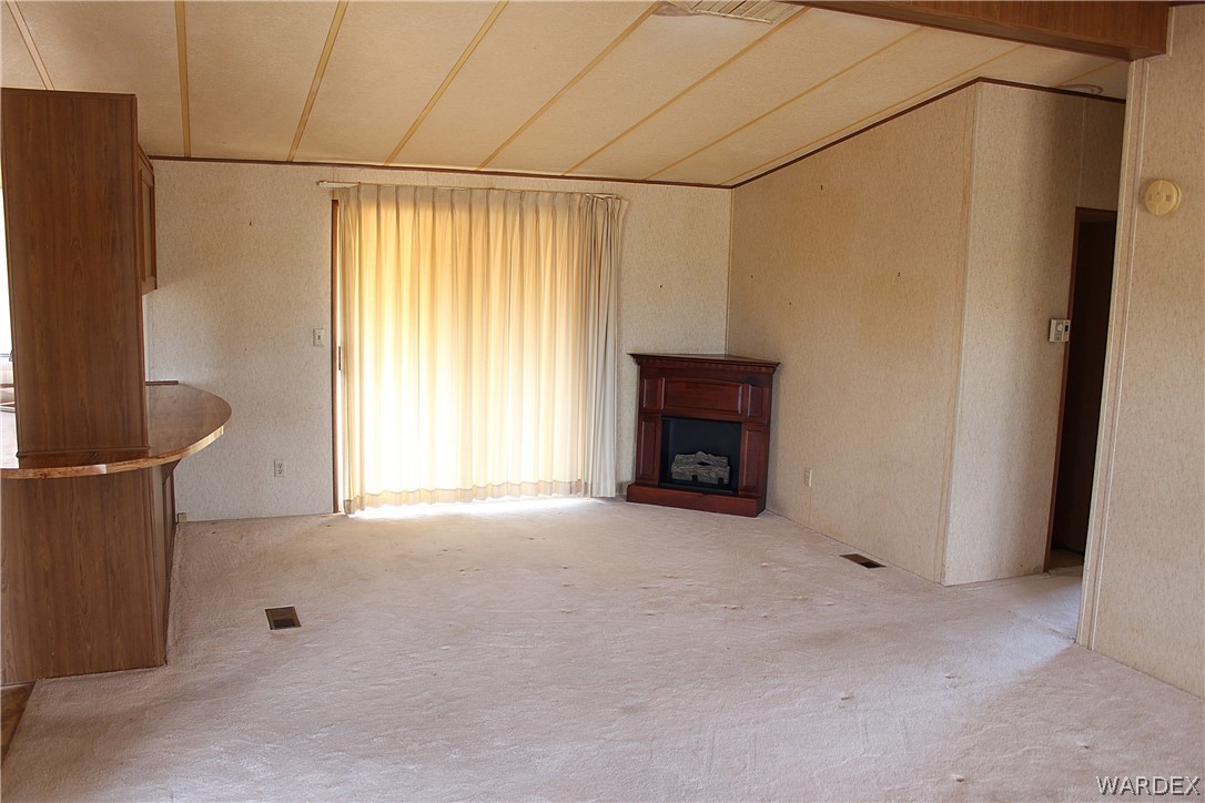 4197 Cordes Road Golden Valley, AZ 86413 - Photo 8 of 51 a view of an empty room with a fireplace and a window