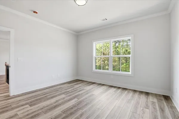 an aerial view of a residential houses with outdoor space and trees all around