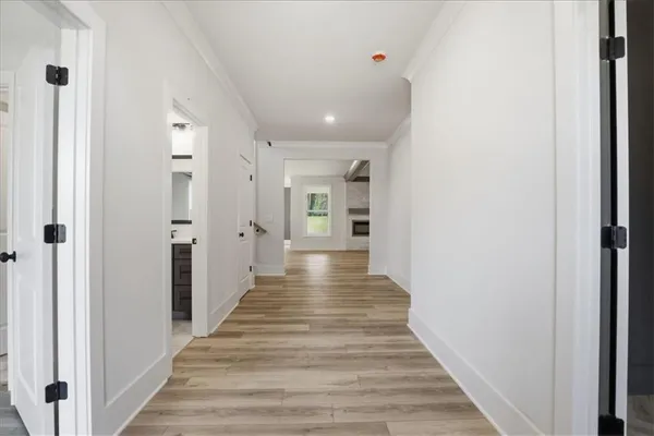 a view of a hallway with wooden floor and windows