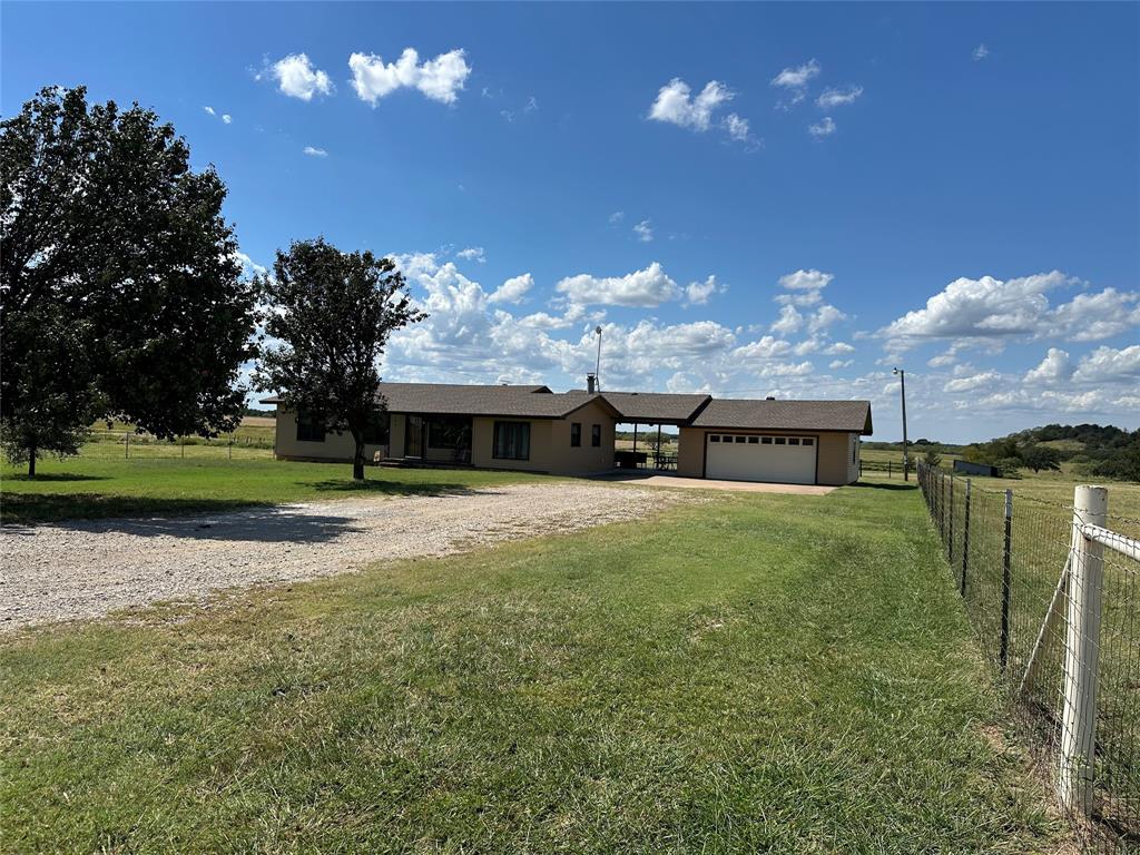 6551 Crooked Creek Road Bowie, TX 76230 - Photo 4 of 39 a view of a house with a yard and a large tree