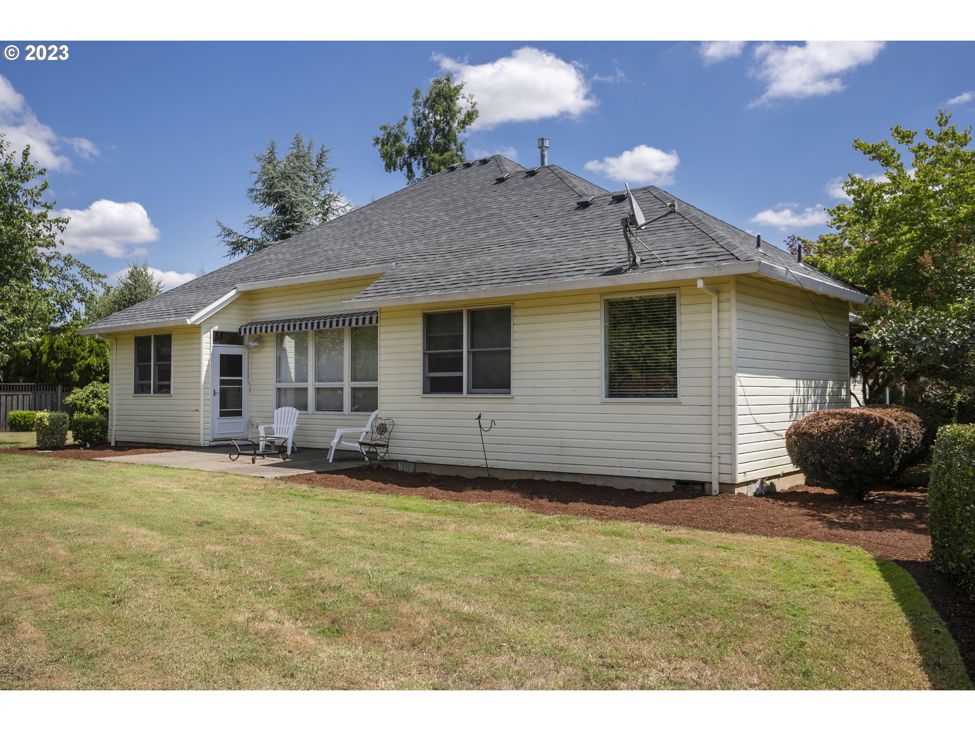 2371 Miller Farm Road Woodburn, OR 97071 - Photo 10 of 33 a backyard of a house with table and chairs potted plants and a large tree