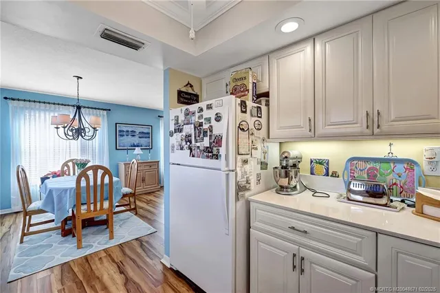 a kitchen with stainless steel appliances granite countertop a refrigerator and a dining table
